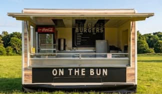 The On The Bun burger van serving at a sunny outdoor pitch